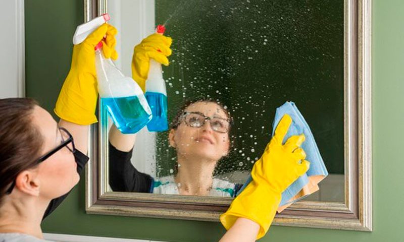 mulher limpando espelho